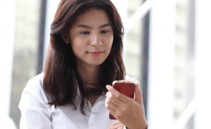 A women looking at a smartphone, using remote monitoring