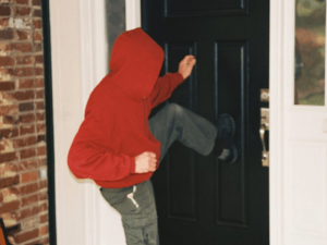 A thug kicking in a door