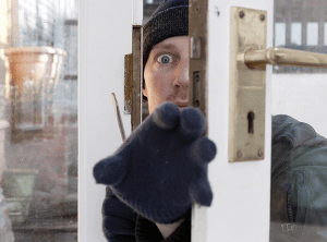 A man attempting home intrusion through the door