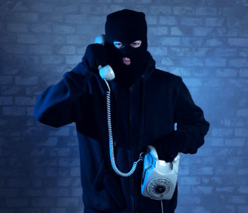 A shadowy figure using a phone for scamming